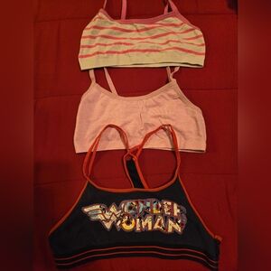 3 small sports bras 1 pink 1 pink & white and 1 blue with wonder woman on front